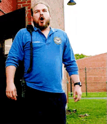 a man with a beard wearing a blue shirt that says law enforcement on it