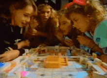 a group of people are playing a board game together .