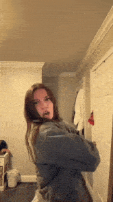 a woman is standing in a room with her arms crossed