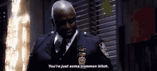 a man in a police uniform is talking to another man in a room .