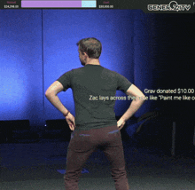 a man in a black shirt is standing in front of a screen that says generosity