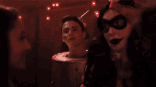 a man with a bucket on his head is surrounded by two girls
