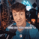 a man wearing headphones is sitting in front of a microphone .