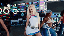 a woman is dancing in front of a sign that says come in