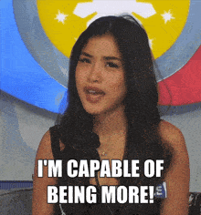 a woman says " i 'm capable of being more " in front of a flag