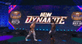 two wrestlers are standing on a stage in front of a sign that says aew dynamite