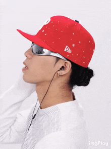 a man wearing a red hat and sunglasses has the letter p on it