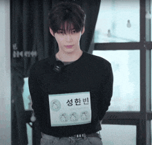a young man wearing a black shirt that says sung han rin on it