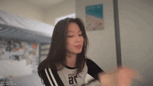 a woman wearing a shirt that says ar looks at the camera with her eyes closed