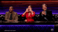 three people are sitting at a table with a nbc logo on the bottom