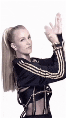 a woman wearing a black and gold adidas jacket