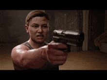 a woman is pointing a gun at something in a video game .