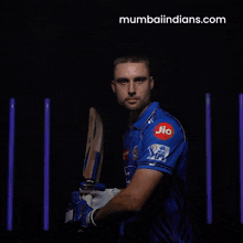 a man holding a bat with a blue shirt that says astra pipes on it