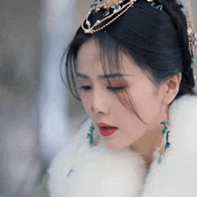 a close up of a woman wearing a tiara and a fur coat