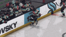 a hockey player stands on the ice in front of a banner that says vsky