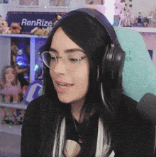 a woman wearing glasses and headphones with a sign that says renrize in the background