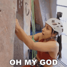 a woman wearing a helmet climbs a rock wall with the words oh my god above her
