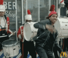 a man is playing drums in front of a mcdonald 's sign
