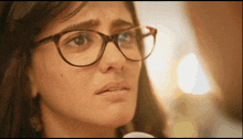 a close up of a woman wearing glasses with a tear running down her face