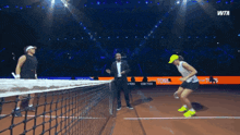 two women are playing tennis on a court with a wta logo in the background