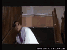 a man in a white shirt and tie is walking down stairs