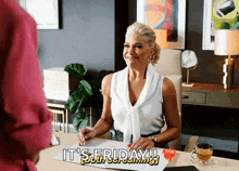 a woman sits at a desk with a sign that says it 's friday !