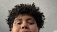 a man with curly hair is making a funny face