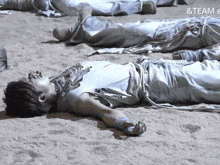a group of people laying in the sand with the word team on the bottom left