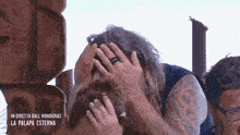 a man with a ring on his finger is covering his face with his hands