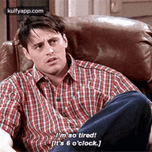 a man in a plaid shirt is laying in a chair and saying `` i 'm so tired ! ''