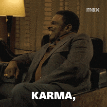a man in a suit and tie is sitting in a chair with the words motherfucker written below him
