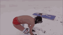 a man without a shirt is standing in the snow