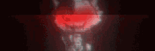 a close up of a person 's face in a dark room with a red light coming out of it .