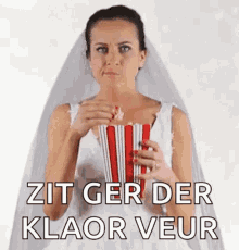 a woman in a bride 's dress is eating popcorn .