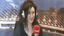 a woman wearing headphones is talking into a microphone with the word radio on it