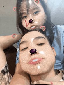 a boy and a girl are posing for a picture with their faces painted with a purple nose
