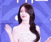 a woman in a white off the shoulder dress is waving