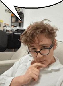 a man wearing glasses is sitting on a couch with a speech bubble above him