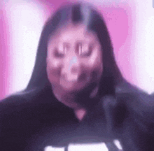 a close up of a woman 's face with her eyes closed and a pink background .