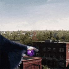 a person in a graduation cap and gown is holding a purple balloon .
