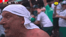 a man wearing a white headband stands in front of a screen that says goal 0
