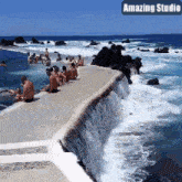 a group of people are swimming in the ocean and the words amazing studio are on the bottom right