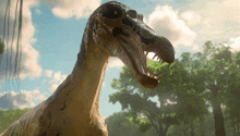 a close up of a dinosaur 's head with its mouth open .