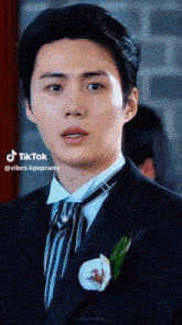 a man in a suit and tie is looking at the camera .