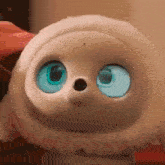 a close up of a stuffed animal with blue eyes and a nose .