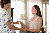a man and woman are holding hands in a living room .