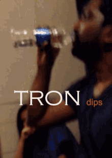 a man drinking from a pepsi bottle that says tron dips on the bottom