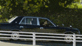 a black car is parked on the side of the road
