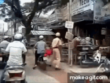 a group of people are riding motorcycles down a street in front of a store .