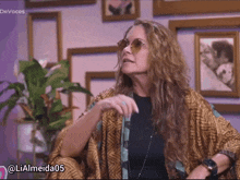 a woman wearing sunglasses is sitting in front of a wall with pictures and the words devoces written on it